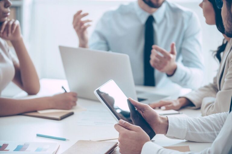 Business professionals collaborating during a planning meeting, representing GBS training, consultancy, growth and digital services.